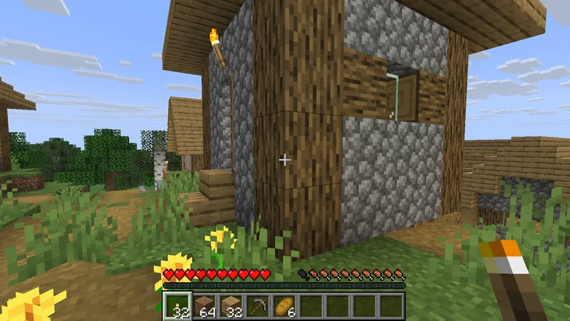 Holding a Torch beside one of the village homes