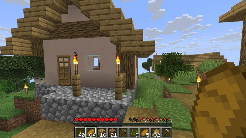 Holding bread outside a village house lit by torches
